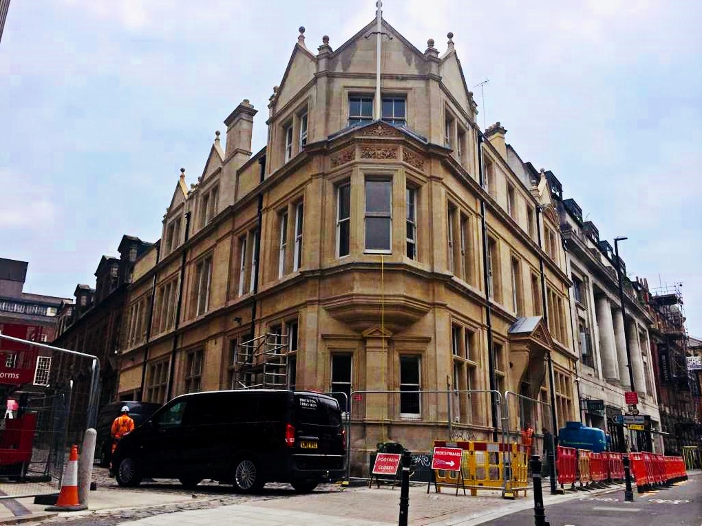Stone building with works going on outside and Building Transformation van in the bottom left