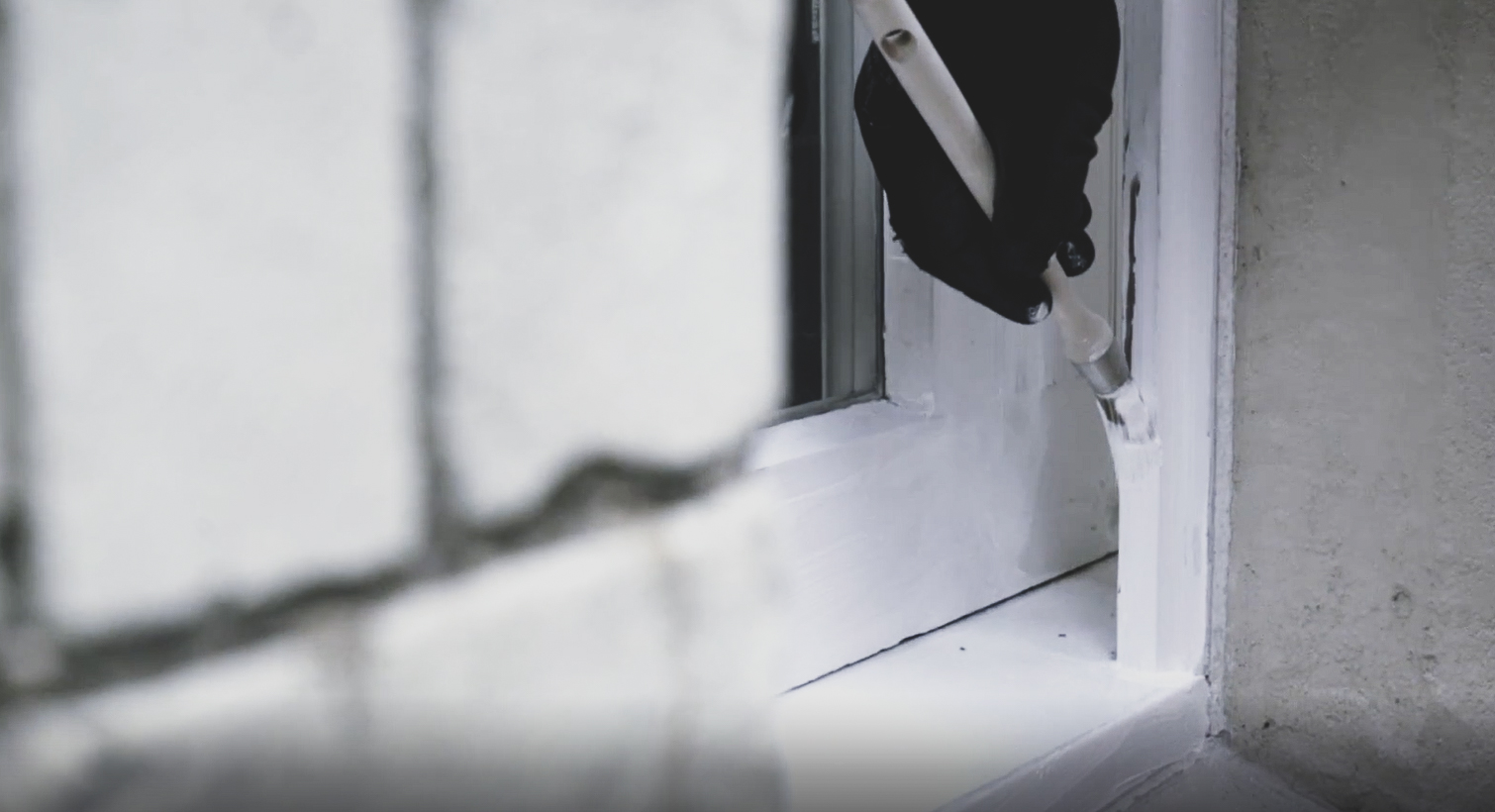 primed window frame being painted white with a paint blush