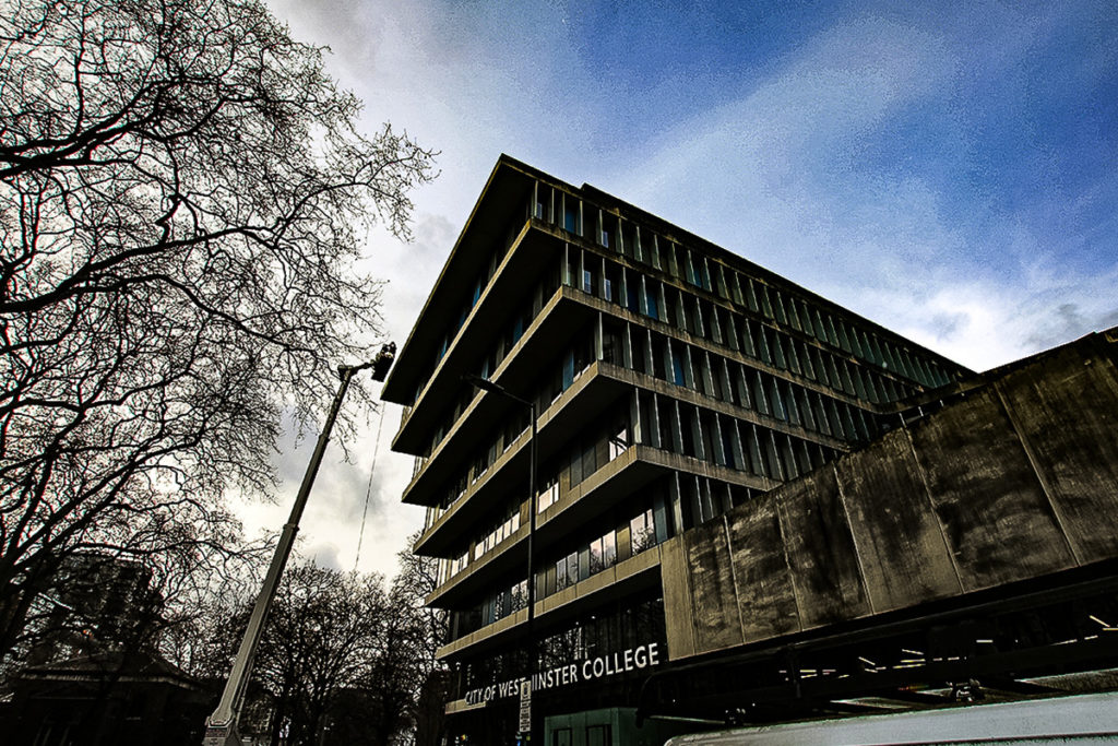 City of Westminster College building under cloudy sky, modern architecture, trees with bare branches.