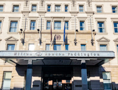 Facade of Hilton London Paddington Hotel with ornate architecture under a clear blue sky.